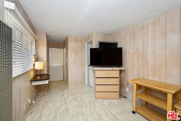 a room with a bed and a television