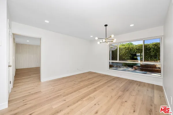 a view of an empty room with wooden floor livingroom and chandelier