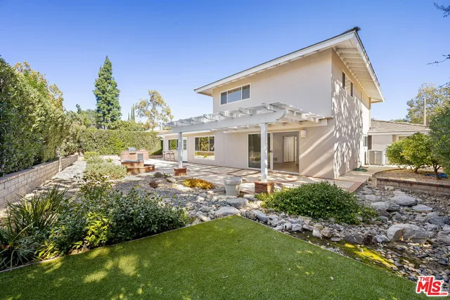 a view of a house with backyard and sitting area
