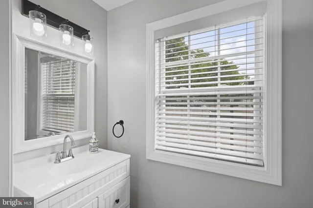 a bathroom with a sink a toilet and a window