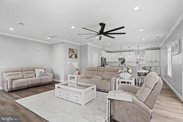 a living room with furniture and a view of kitchen