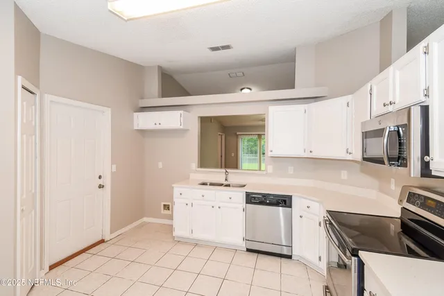 a kitchen with a stove sink and a refrigerator
