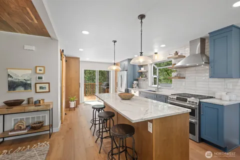 a kitchen with stainless steel appliances granite countertop a stove and a wooden cabinets