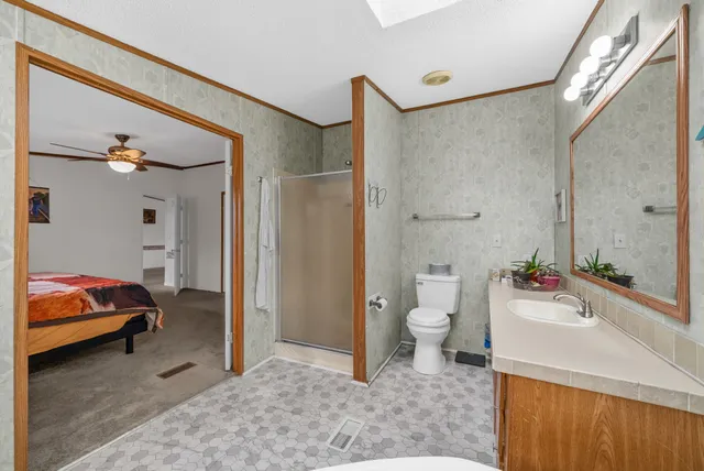 a en suite bathroom with a granite countertop sink and a mirror