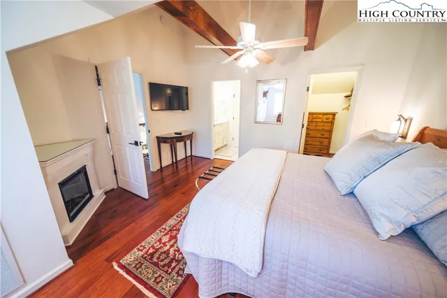 a bedroom with a bed tv and a fireplace