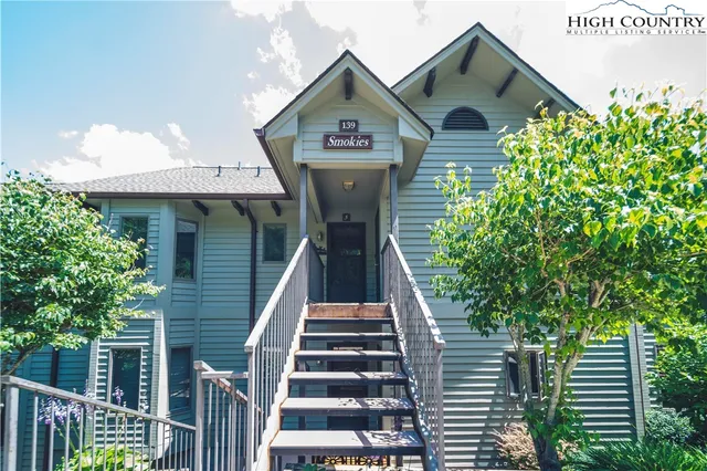 a view of a big house with large windows and a palm tree