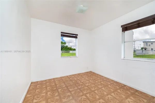a view of a bedroom with wooden floor and a window