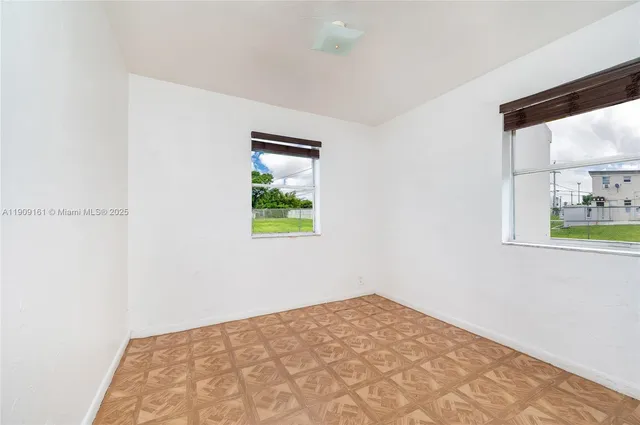 a view of a bedroom with wooden floor and a window