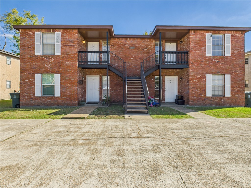 front view of a brick house with a yard
