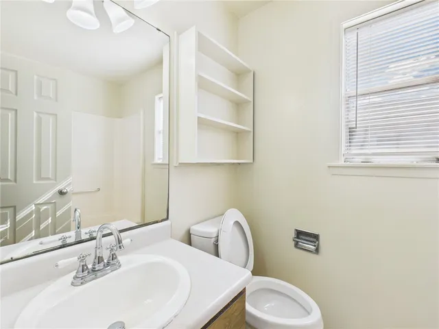 a bathroom with a sink toilet and mirror