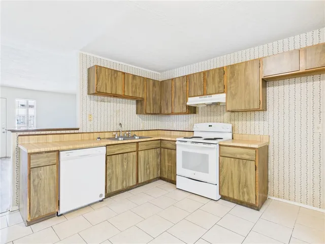 a kitchen with a stove top oven sink and cabinets
