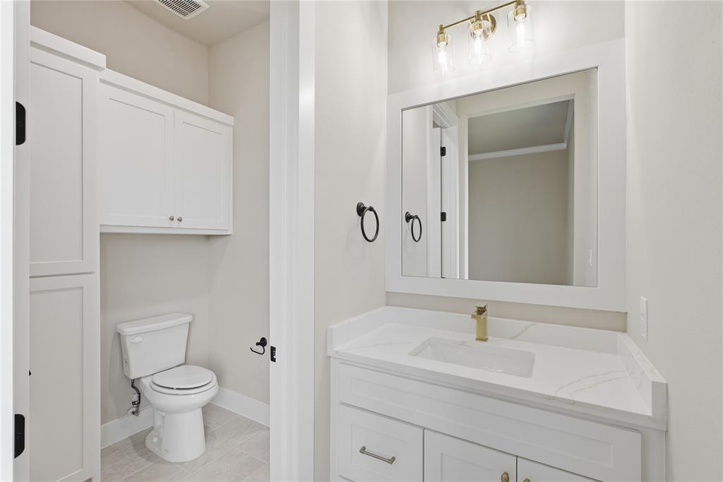 709 Anne Road Van Alstyne, TX 75495 - Photo 13 of 28 White vanity with a rectangular undermount sink and brass-finish faucet