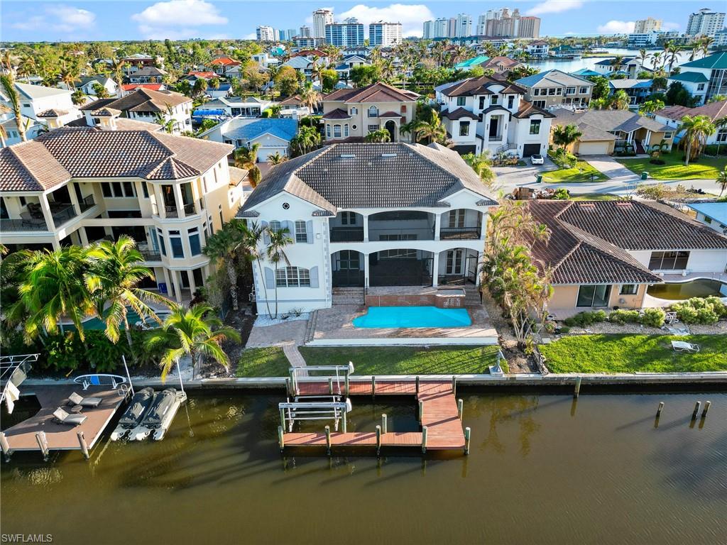 an aerial view of residential houses with outdoor space and lake view