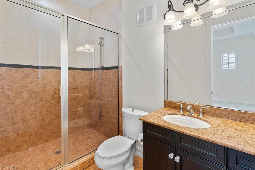 405 Trade Winds Avenue Naples, FL 34108 - Photo 11 of 48 a bathroom with a granite countertop sink toilet a mirror and shower