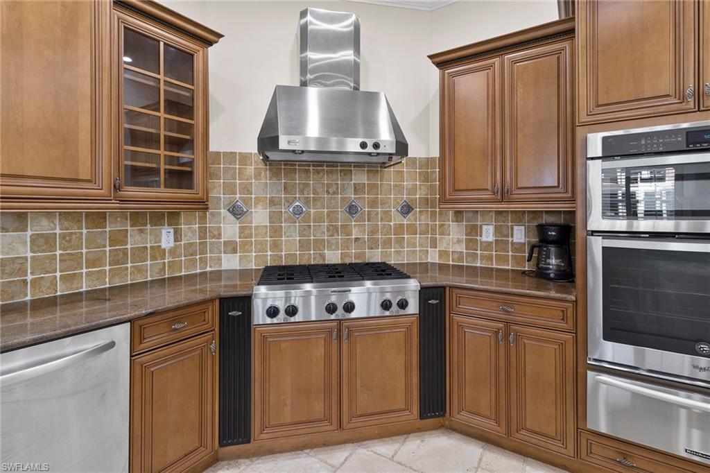 405 Trade Winds Avenue Naples, FL 34108 - Photo 12 of 48 a kitchen with granite countertop a stove sink and cabinets