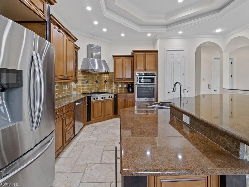 405 Trade Winds Avenue Naples, FL 34108 - Photo 14 of 48 a kitchen with stainless steel appliances granite countertop a refrigerator a stove and a sink