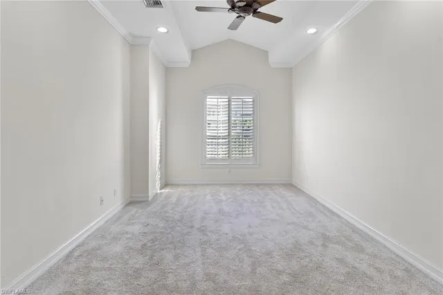 en empty room with windows and ceiling fan