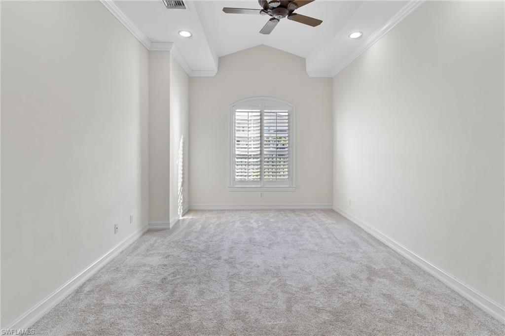 405 Trade Winds Avenue Naples, FL 34108 - Photo 29 of 48 an empty room with a chandelier fan and windows