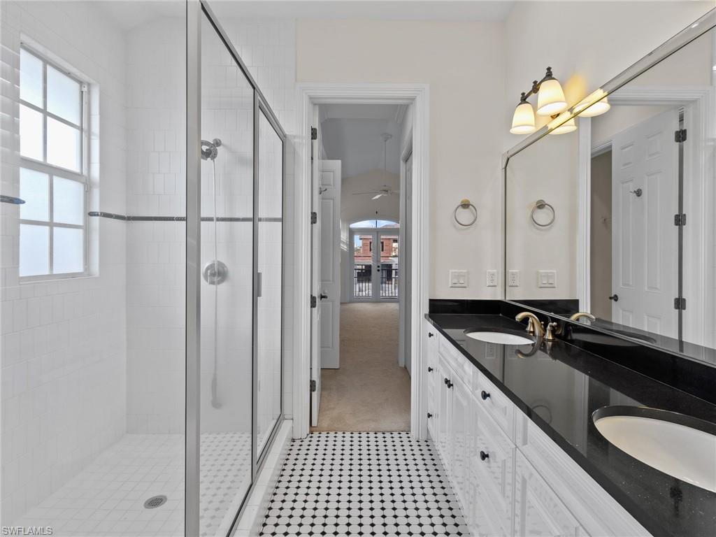 405 Trade Winds Avenue Naples, FL 34108 - Photo 31 of 48 a spacious bathroom with a granite countertop sink a mirror and shower