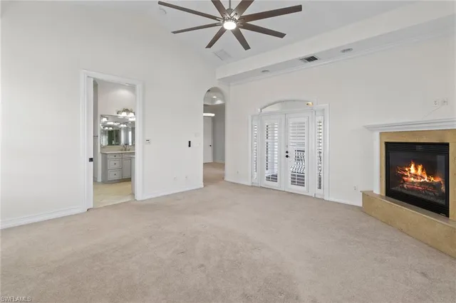 an empty room with windows and fireplace