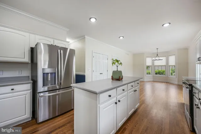 a kitchen with kitchen island a counter top space a sink and stainless steel appliances