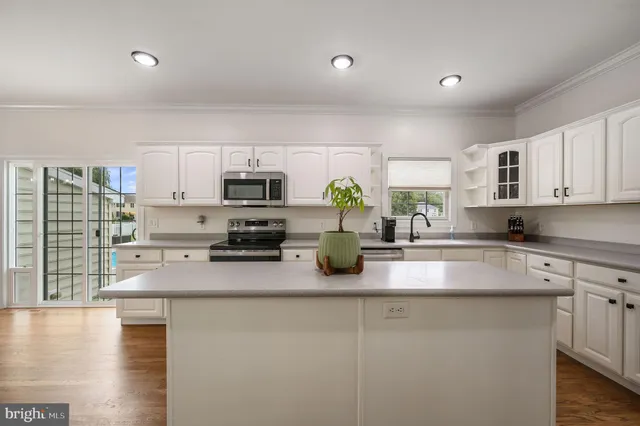 a kitchen with stainless steel appliances a sink a stove top oven a counter space and cabinets