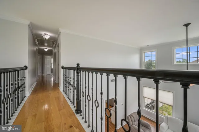 a view of a hallway with wooden floor and staircase