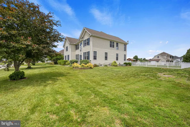 a big white house with a big yard and large trees