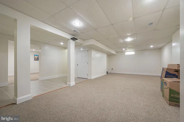 an empty room with a cabinet and mirrors