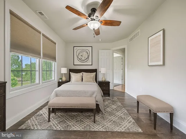 a bedroom with a bed and a large window