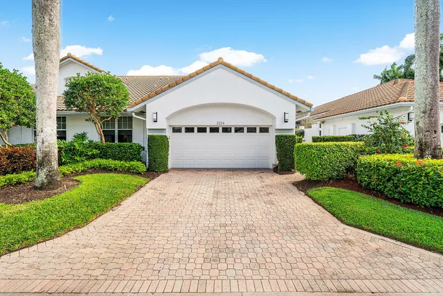 a front view of a house with a yard and potted plants