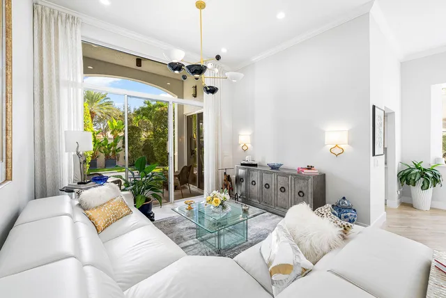 a living room with furniture chandelier and a large window
