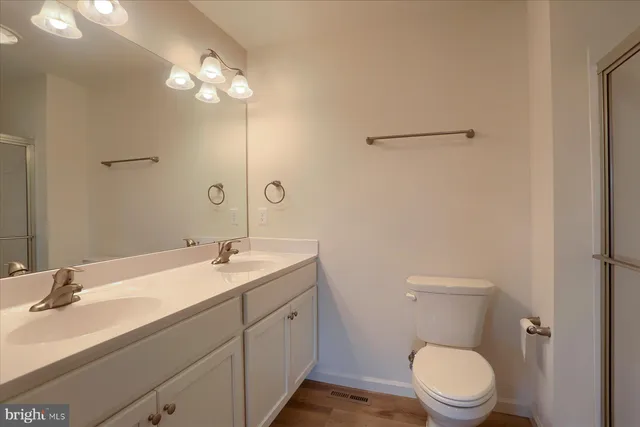 a bathroom with a toilet a sink a mirror and vanity
