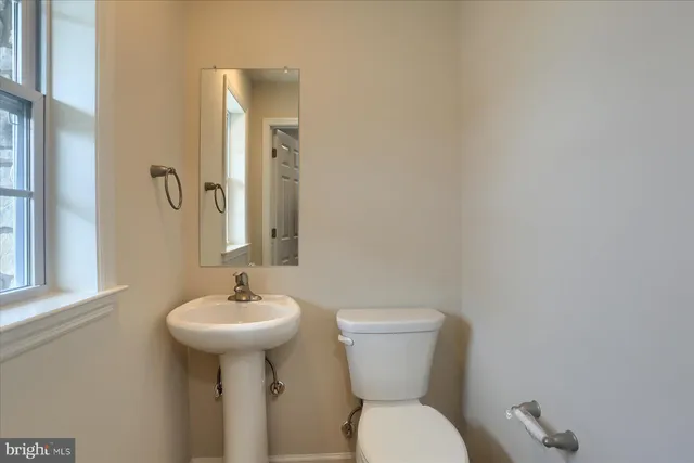 a bathroom with a toilet sink and mirror