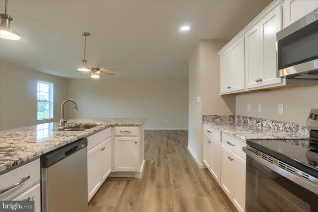 a kitchen with granite countertop a sink stove and cabinets