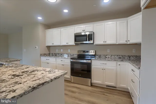 a kitchen with granite countertop a sink and cabinets