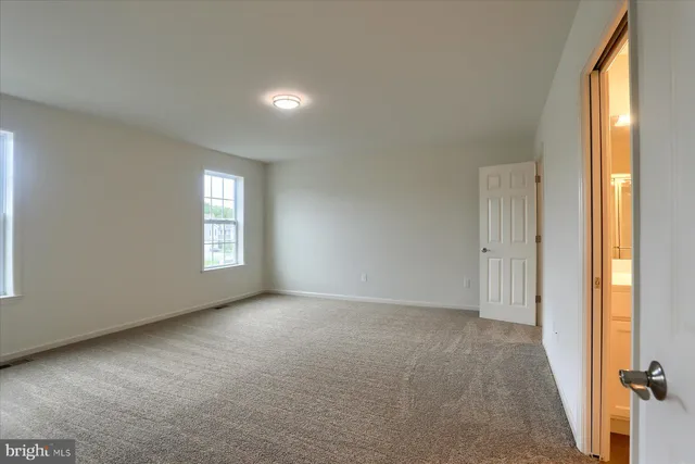an empty room with windows and closet