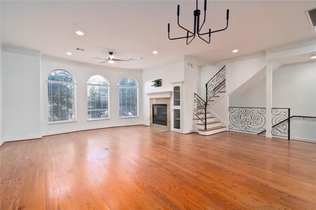 a view of an empty room with a fireplace and wooden floor