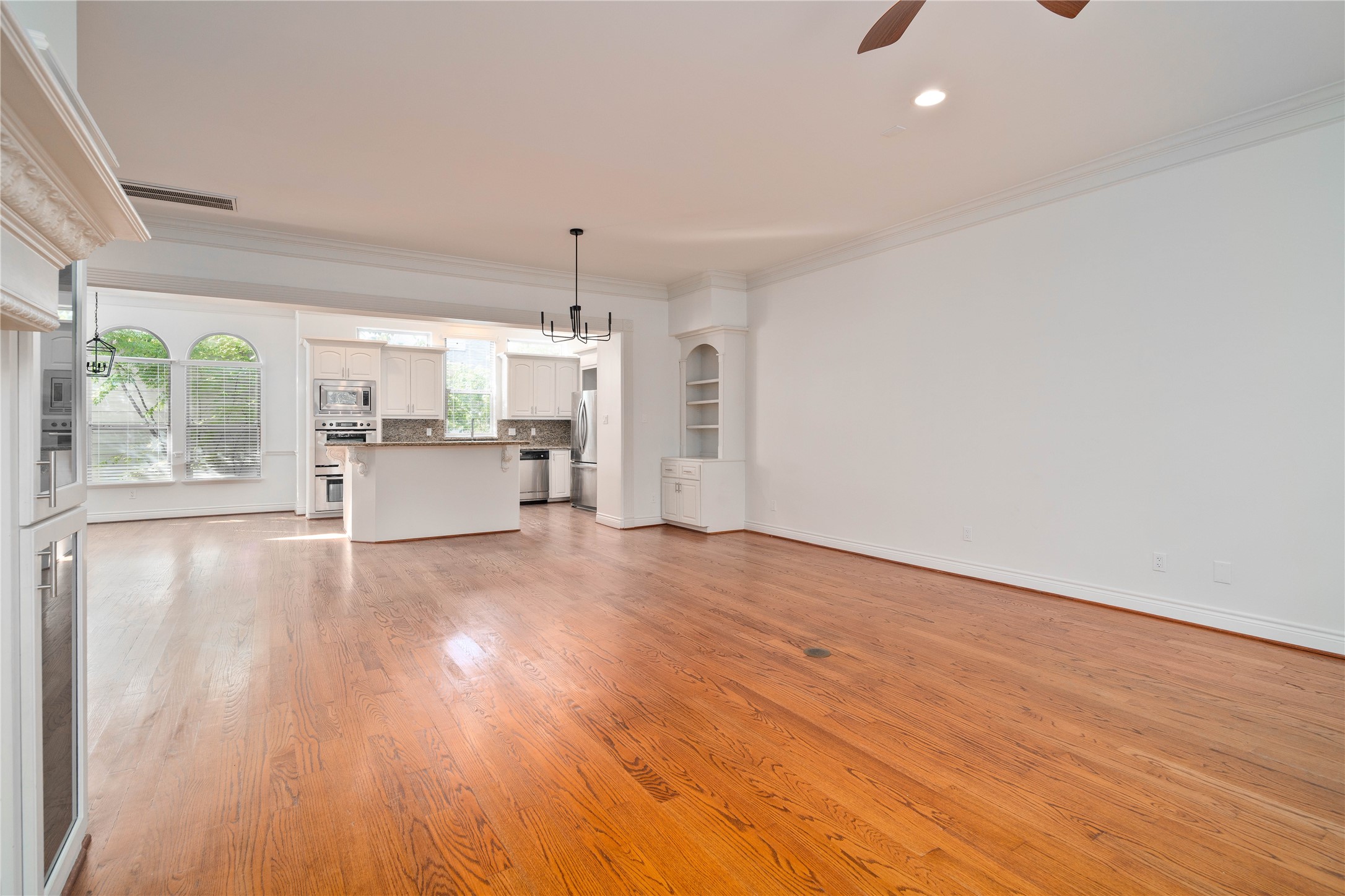 704 Welch Street Houston, TX 77006 - Photo 13 of 23 a view of empty room with wooden floor and fan