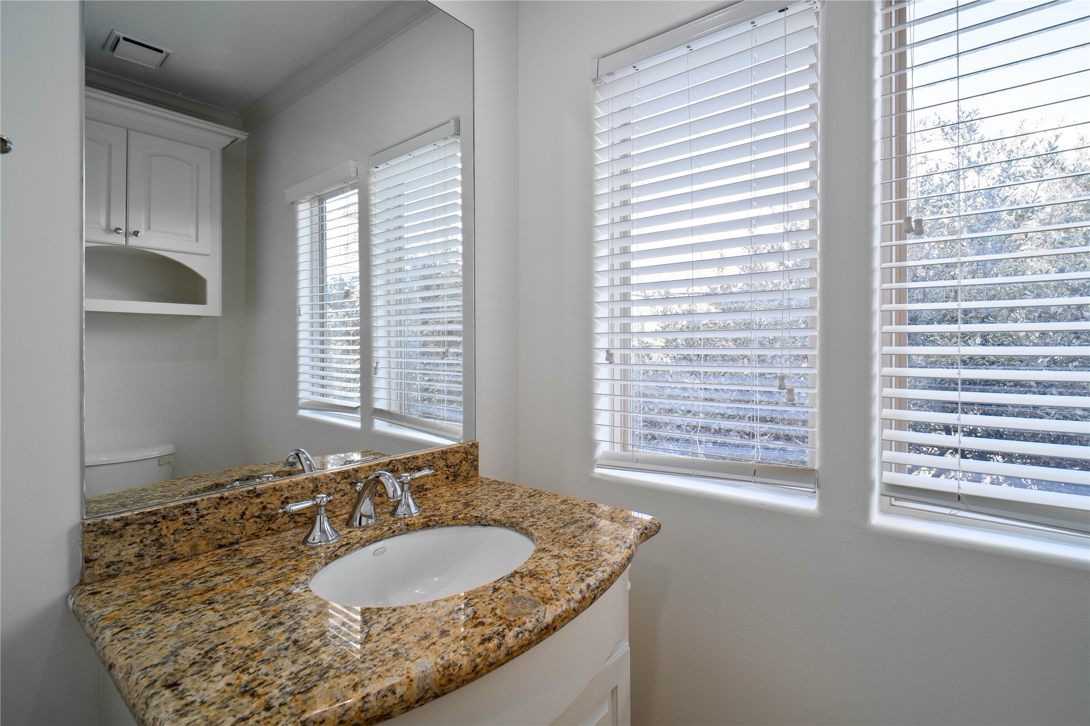 704 Welch Street Houston, TX 77006 - Photo 14 of 23 a bathroom with a granite countertop sink and a window