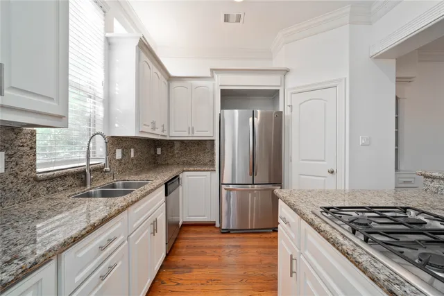 a kitchen with granite countertop a sink stove and refrigerator