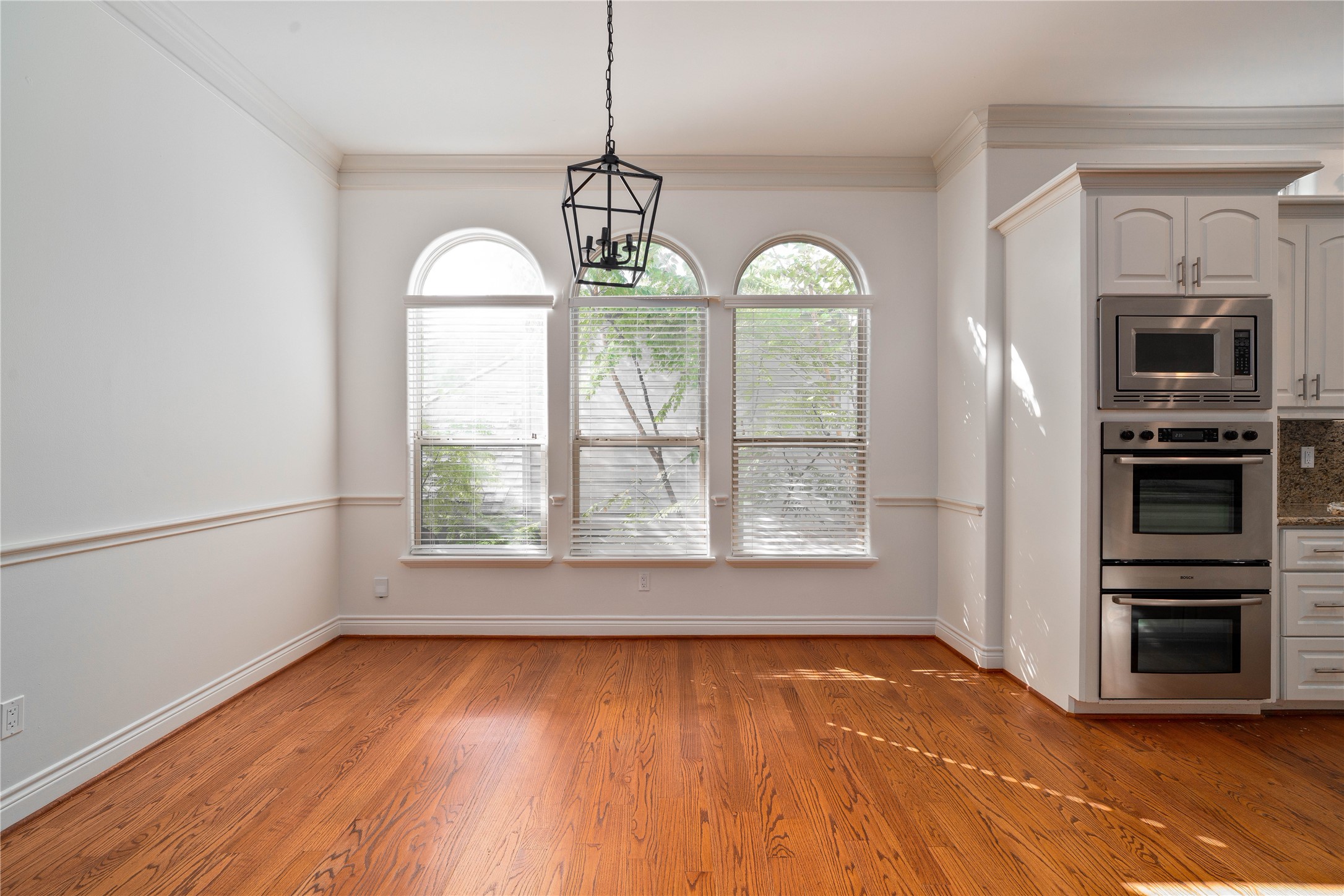 704 Welch Street Houston, TX 77006 - Photo 8 of 23 wooden floor in an empty room with a window