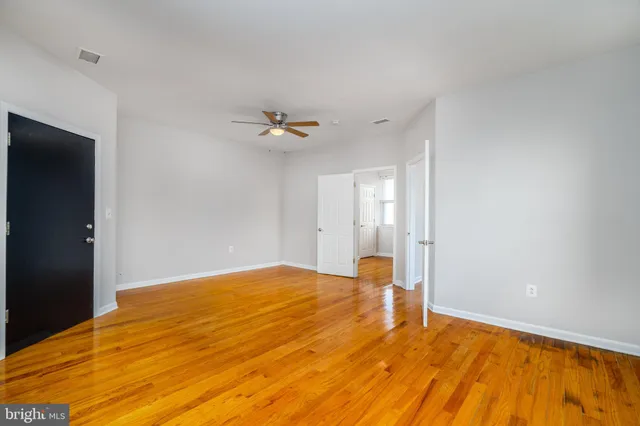 a view of empty room with wooden floor