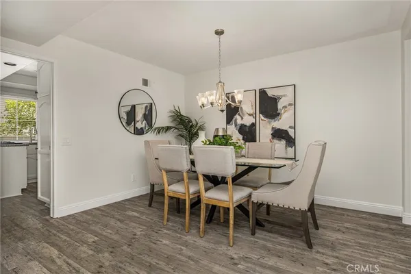a dining room with furniture a chandelier and wooden floor