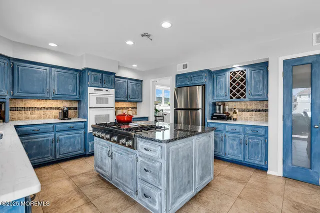 a kitchen with stainless steel appliances granite countertop a stove refrigerator and cabinets