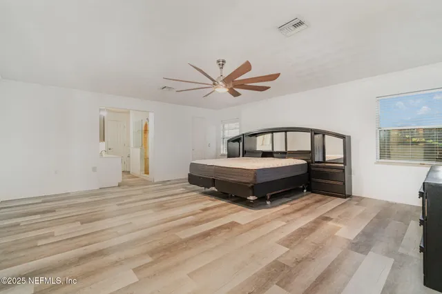 a spacious bedroom with a bed and window