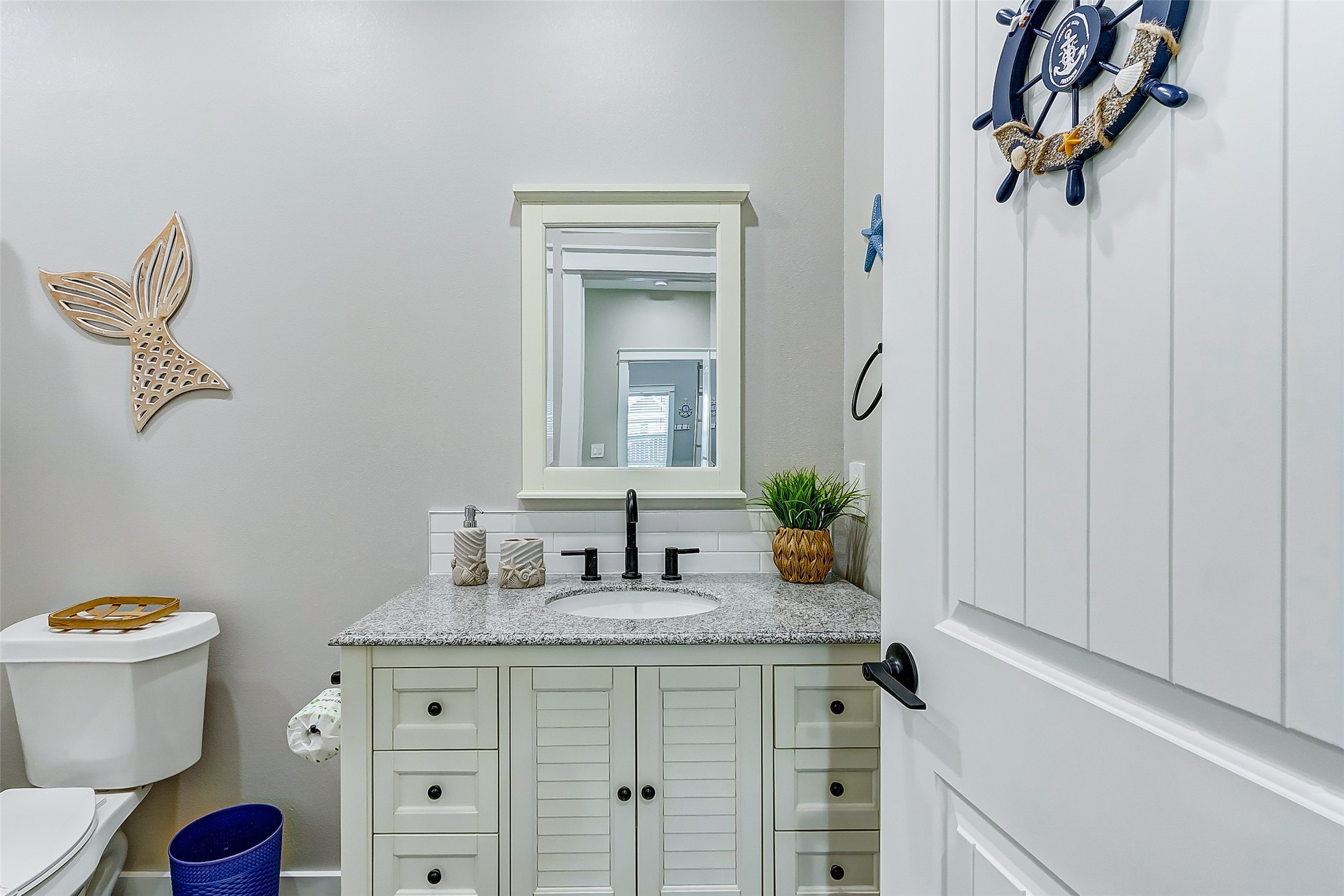 1052 Johnson Road Port Bolivar, TX 77650 - Photo 29 of 40 a bathroom with a granite countertop sink a toilet and mirror