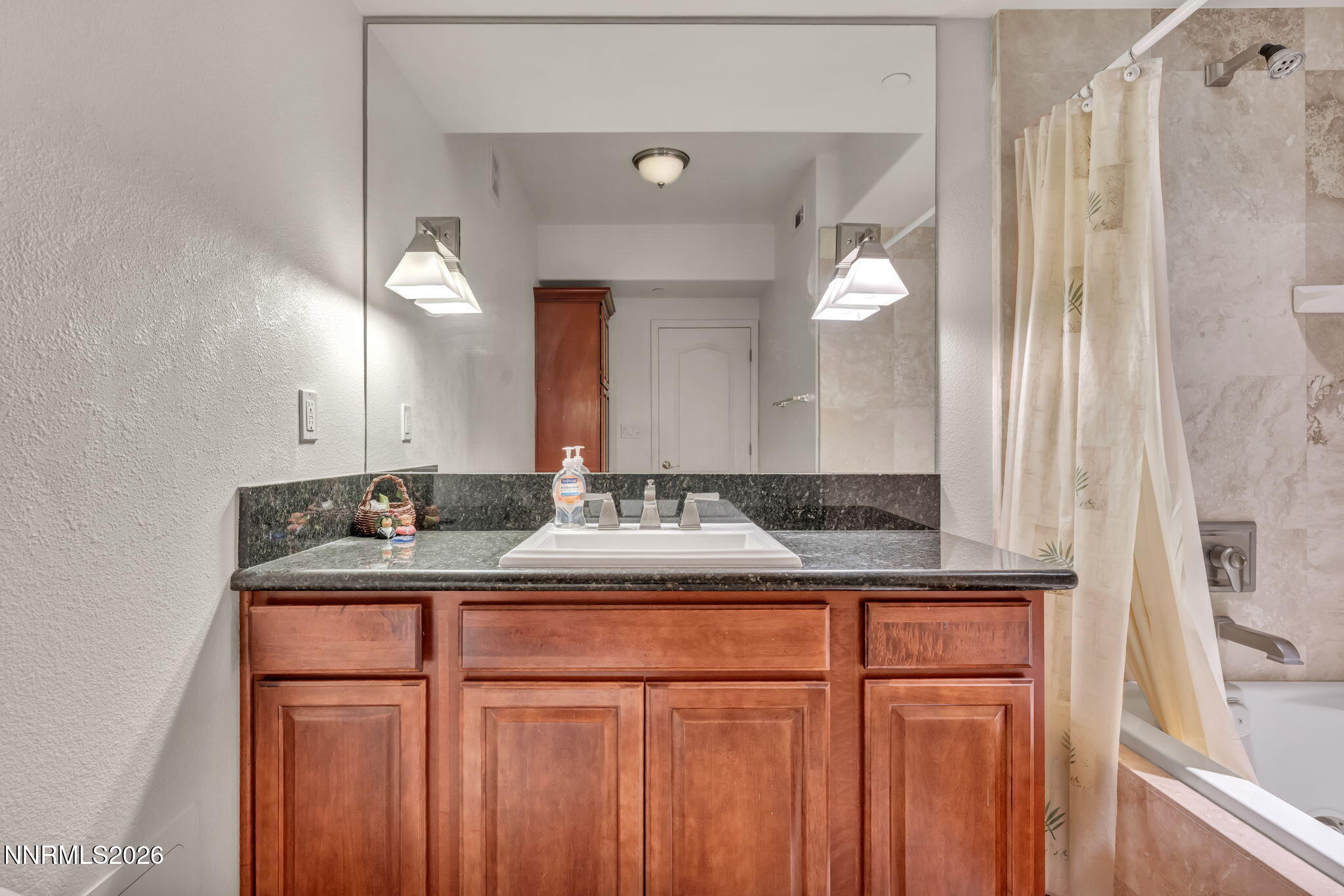 200 West 2nd Street, Unit 1103 Reno, NV 89501 - Photo 34 of 49 a bathroom with a granite countertop sink and a mirror