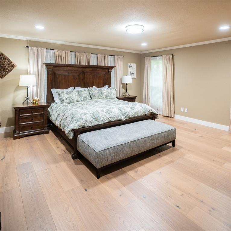 1451 Meandro Ria Lane Fairview, TX 75069 - Photo 25 of 38 a spacious bedroom with a bed and wooden floor