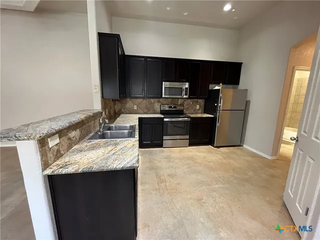 a kitchen with a sink stove and refrigerator